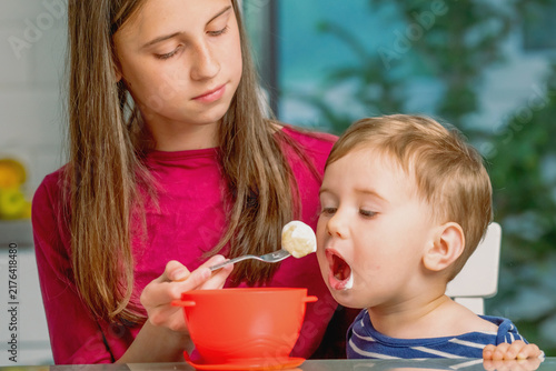 Warm relationship between older sister and younger brother at home.