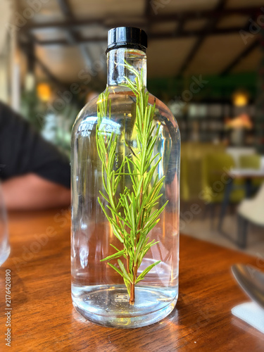 Bottle of water infused with a spring of rosemary