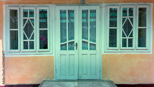White-painted wooden door and two windows on a historic 19th-century Romanian house