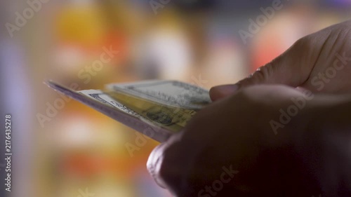 Person calculates 100 dollar cash in hands. Close up. Blurred background. Insurance concept