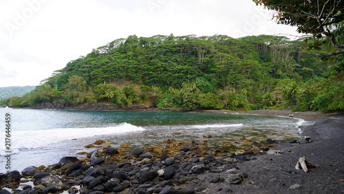 фотографія Dark basalt rocks and volcanic black sand border a secluded cove at Trou du Souf