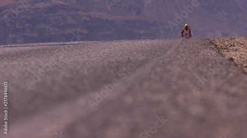 Long lens shot of marathon athlete running in the heat of death valley