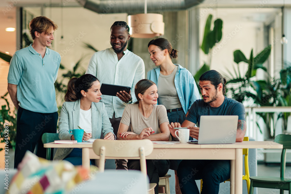 Obraz premium Diverse business team collaborating, young people brainstorming ideas and discussing project strategy in a modern office environment
