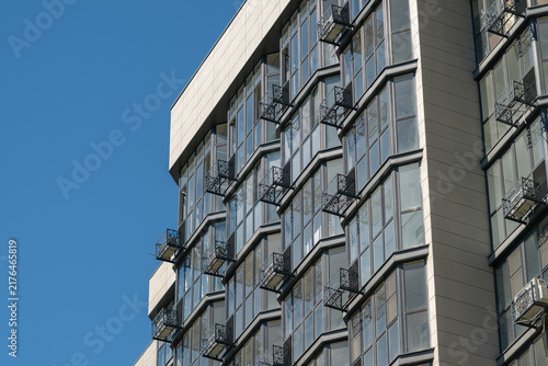 Canvas Print Building with multiple balconies against a clear blue sky in an urban setting du