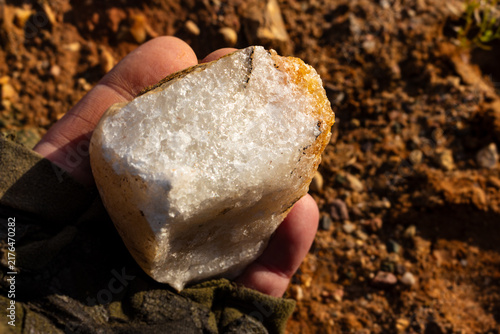 Obraz na plátně Split white quartz boulder with a sparkling sugary texture held in hand, showing
