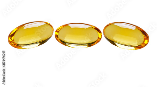 Obraz na plátne Three translucent golden oval softgel capsules, isolated on transparent backgrou