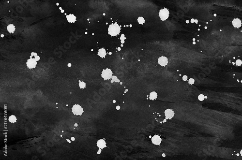 White ink dripping on paper isolated on a black
