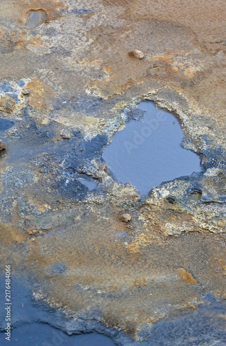 Fotografie Close-up view of colorful mineral textures and small geothermal pools at Hverir in Iceland, revealing eroded volcanic ground and sulfur-rich deposits