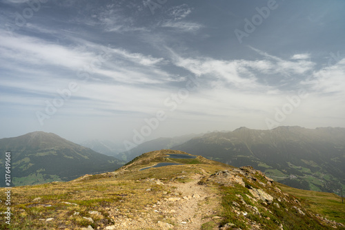 Alpine Mountain Trail Leading To Small Mountain Lakes With Panoramic Valley And Distant Peaks