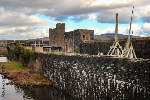 Foto Reconstructed medieval siege weapons standing beside high stone walls at Caerphi