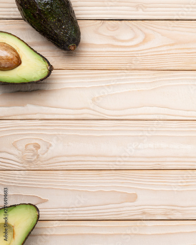 Minimal avocado background on light wooden surface