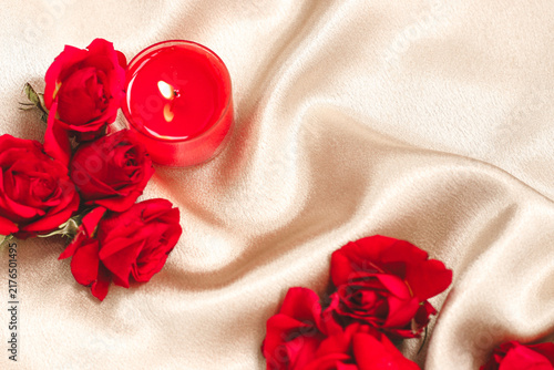 Obraz na plátně Roses and a red candle on soft fabric create a romantic setting for a special oc