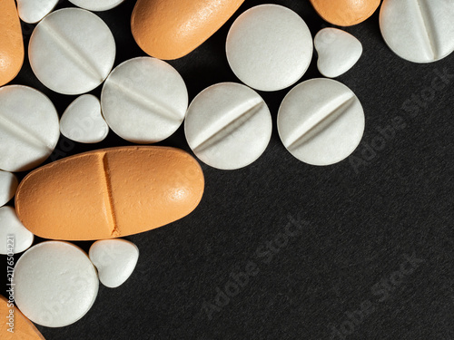 Foto Close-Up Of Orange And White Pills And Tablets On Black Background For Medicine