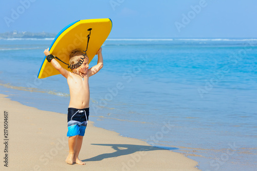 Bild auf Leinwand Portrait of little surfer boy with bodyboard have fun on beach, walk by white sand beach