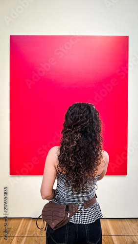 Fotografía Woman viewing red painting in art gallery