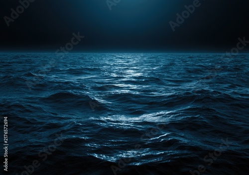 Deep blue ocean with moonlight reflecting on choppy waves at night