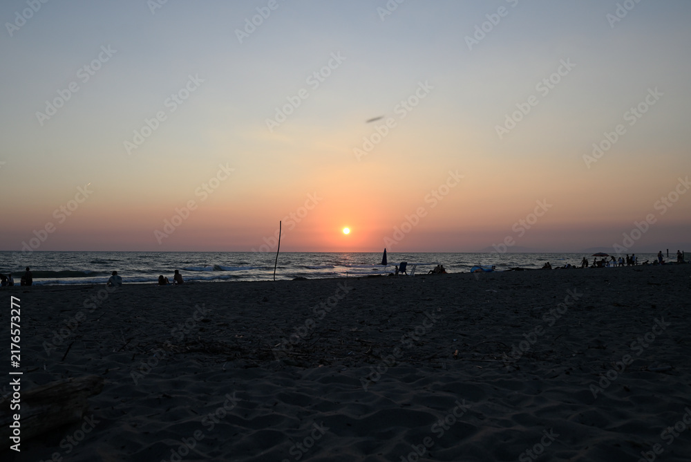 Obraz premium People enjoying sundown at tuscany beach. Togetherness at italian beach. Marina di Torre del LAgo, Tuscany, Italy, Europe.