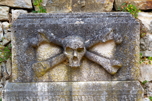 Carved Stone Skull and Crossbones Relief on Antique Tombstone in Buje Istria