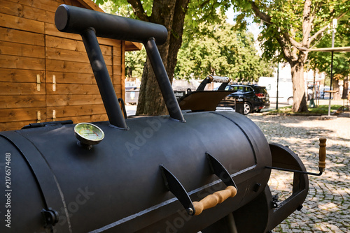 Black barbecue smoker with temperature gauge in outdoor setting