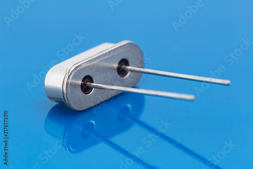 Photography Silver component with two metal pins rests on blue surface