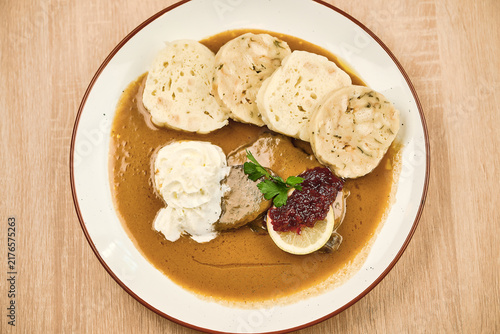 Traditional Czech dish with sliced meat, dumplings, and sauce