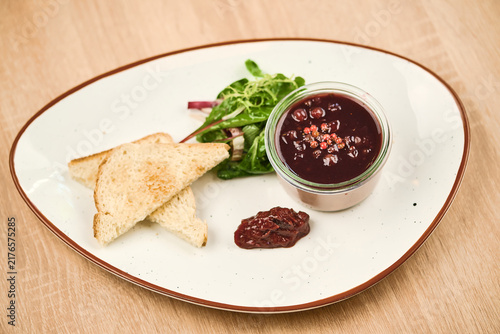 Gourmet dish with toast, salad, and berry compote in glass jar