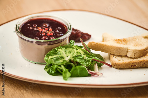 Gourmet appetizer with pate, salad, and toasted bread on a plate