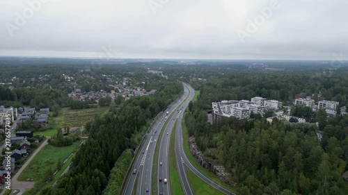 Aerial drone view of the highway intersection of Ring I and Tuusulanväylä in the Patola and Pakila area of Helsinki, Finland, with cars and traffic visible on the roads during summer.