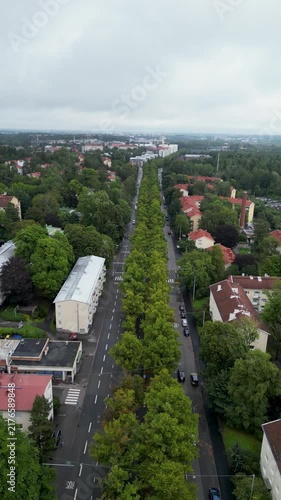 aerial drone video of Koskelantie in the Käpylä area of Helsinki, Finland, surrounded by lush green trees and urban residential buildings during summertime.
