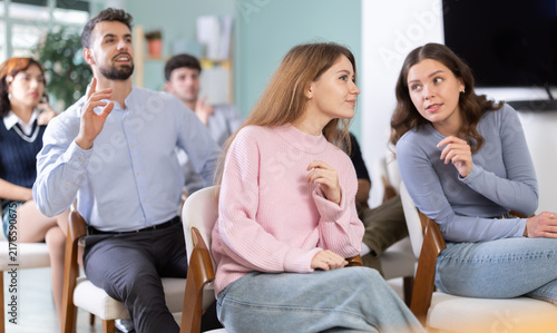 Картината върху платно Two interested young students busy with mutual conversation during educational t