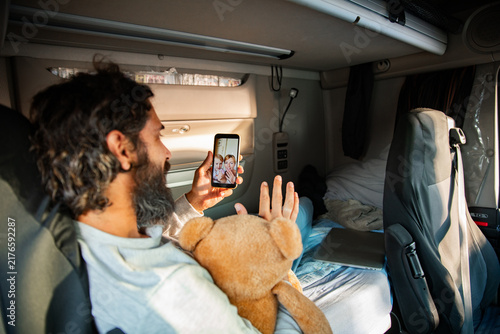 Truck driver video calling family in sleeper cab
