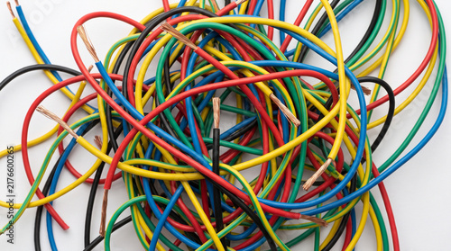 Colorful electrical wire bundle with exposed copper ends on white background, creating tangled industrial wiring pattern