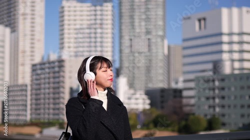 ヘッドフォンを付けて音楽を聴く女性