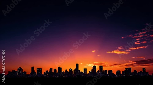 Vibrant sunset orange and purple sky over a silhouetted city skyline at dusk.