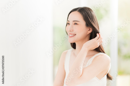鏡を見ながら髪を触る日本人女性