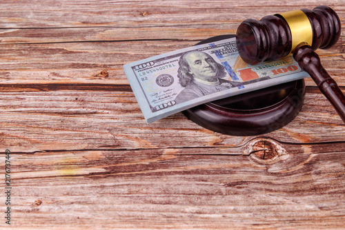 Fotografie Overhead view of a mahogany judge gavel crushing hundred Dollar bills