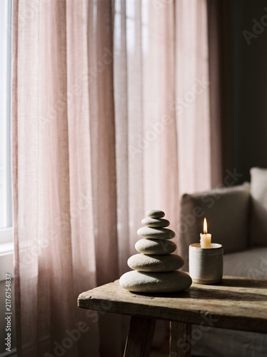 Zen Spa Still Life with Stacked Stones and Burning Candle on Rustic Wooden Table against Soft Pink Linen Curtains, Minimalist Interior Decor for Wellness, Meditation, Relaxation, and Calm Atmosphere