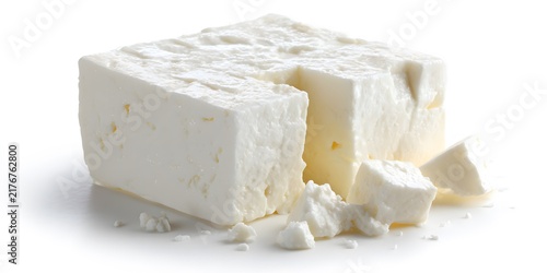 Fresh white feta cheese block with crumbled pieces isolated on a white background
