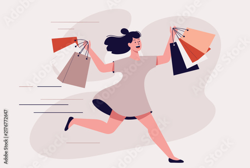 Excited happy young woman running fast while holding many paper shopping bags in hands on light pink background.