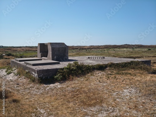 фотографія Concrete bunker ruin structure located in an open grassland field with concrete