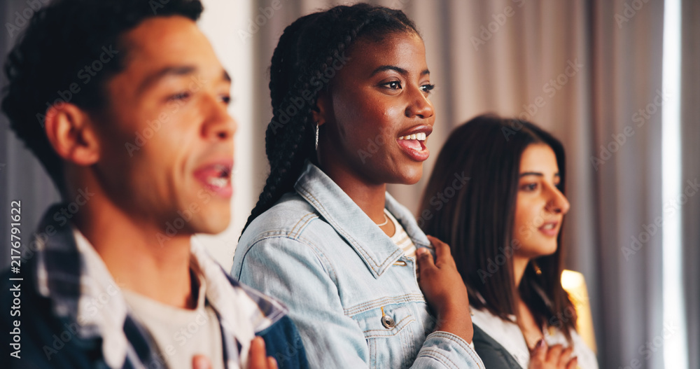 Fototapeta premium People, anthem and watching tv with support in home for national day, inspiration or team spirit. Unity, citizens or group of fans singing with smile, pride or honor for sports game or match in house