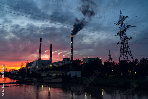 Konstfotografi Power plant smokestacks emitting dark smoke at sunset reflecting industrial poll