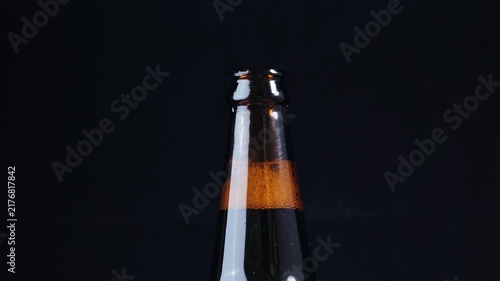 Beer bottle and the condensation of beer gas rises up from the neck. 