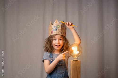 Young Girl Scientist Holding Glowing Light Bulb