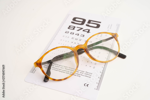 Canvas Print Glasses on eye testing exam chart to check eyesight accuracy of reading