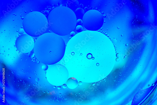 Fotografie Microscopic cells floating in blue liquid background