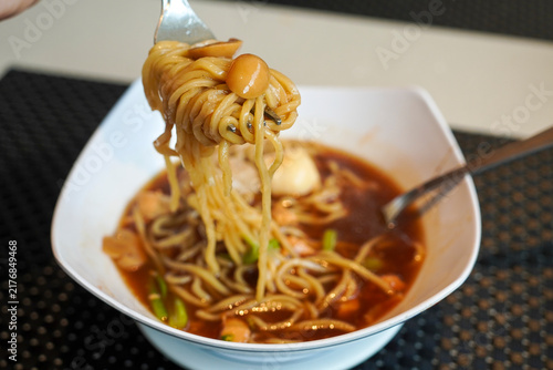 Konstfotografi Fork lifting delicious hot noodle soup with meatballs in a white bowl