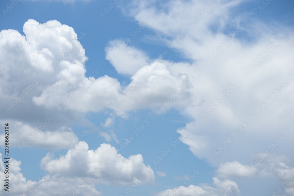 Obraz premium fluffy white clouds building up in the light blue sky