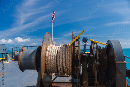 Photography Weathered Ferry Winch and Coiled Rope Beneath Thai Flag