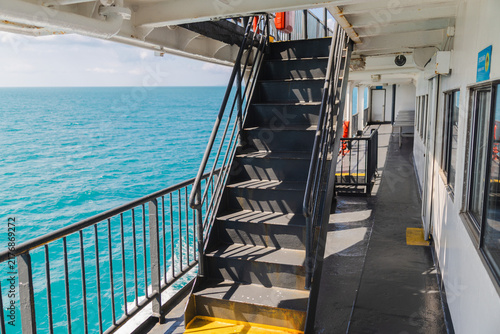 Foto Black Staircase and Covered Walkway on Ferry Above Turquoise Sea